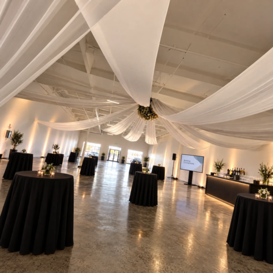 Cocktail reception with black linen tables and a lit bar at The Zion